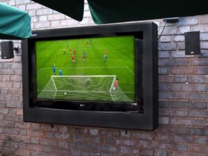 football match on a outdoor TV mounted to a wall in an Armagard screen enclosure